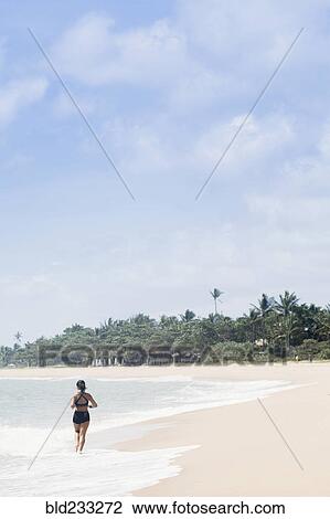 Mixed Race girl running on beach in waves View Large Photo Image Stock Image - Mixed Race girl running on beach in waves. Fotosearch