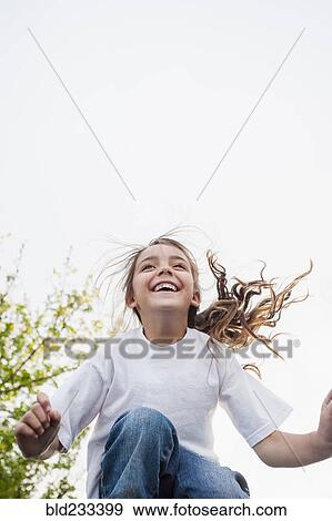 Mixed Race girl smiling and jumping View Large Photo Image Stock Photo - Mixed Race girl smiling and jumping. Fotosearch