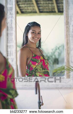 Stock Photo - Mixed Race girl smiling in mirror. Fotosearch