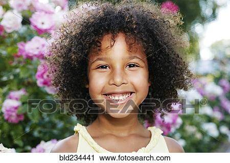 Stock Image - Mixed Race girl smiling outdoors. Fotosearch