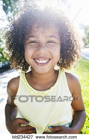 Mixed Race girl smiling outdoors View Large Photo Image Stock Photo - Mixed Race girl smiling outdoors. Fotosearch
