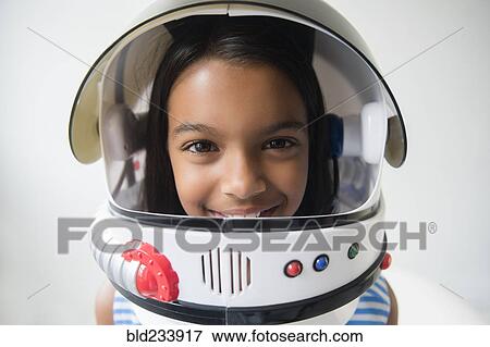 Stock Photo - Mixed Race girl wearing astronaut helmet. Fotosearch