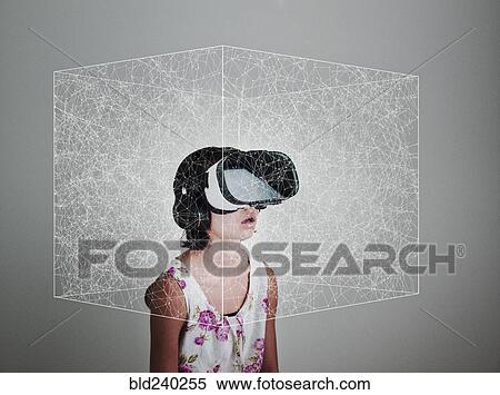 Stock Photography - Mixed Race girl wearing virtual reality goggles in floating box. Fotosearch