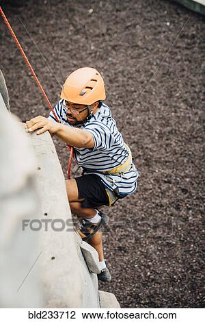 Mixed Race man climbing rock climbing wall View Large Photo Image Stock Image - Mixed Race man climbing rock climbing wall. Fotosearch