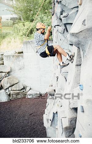 Mixed Race man climbing rock climbing wall View Large Photo Image Stock Photograph - Mixed Race man climbing rock climbing wall. Fotosearch