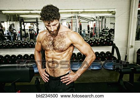 Mixed Race man resting in gymnasium View Large Photo Image Stock Image - Mixed Race man resting in gymnasium. Fotosearch