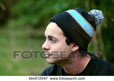 Mixed race man sitting outdoors in cap View Large Photo Image Stock Photo - Mixed race man sitting outdoors in cap. Fotosearch