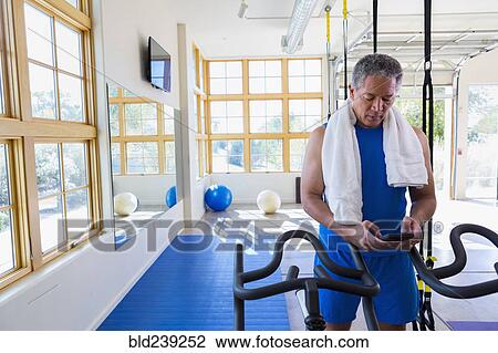 Mixed Race man texting on cell phone in gymnasium View Large Photo Image Stock Image - Mixed Race man texting on cell phone in gymnasium. Fotosearch