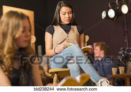 Mixed Race teenage girl reading script in theater class View Large Photo Image Picture - Mixed Race teenage girl reading script in theater class. Fotosearch