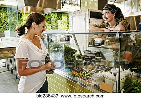 Stock Photo - Mixed Race woman and worker in food court. Fotosearch