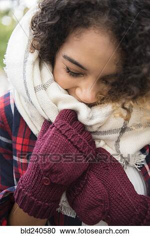 Stock Image - Mixed Race woman covering face with scarf. Fotosearch