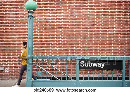 Stock Photo - Mixed Race woman exiting subway station in city. Fotosearch