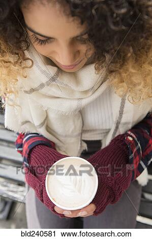 Mixed Race woman holding coffee cup with leaf in foam View Large Photo Image Stock Image - Mixed Race woman holding coffee cup with leaf in foam. Fotosearch