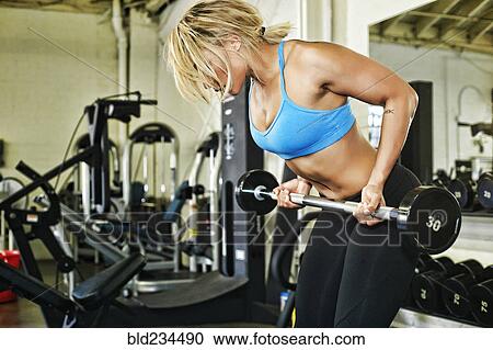 Mixed Race woman lifting barbell in gymnasium View Large Photo Image Stock Image - Mixed Race woman lifting barbell in gymnasium. Fotosearch
