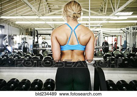 Mixed Race woman lifting barbell in gymnasium View Large Photo Image Stock Photo - Mixed Race woman lifting barbell in gymnasium. Fotosearch