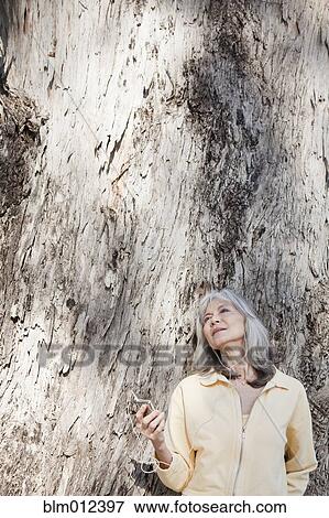 Stock Photo - Mixed race woman listening to mp3 player outdoors. Fotosearch