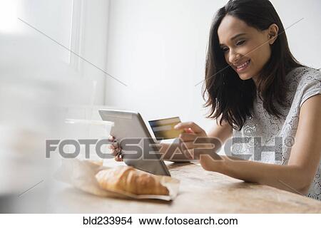 Mixed Race woman online shopping with credit card View Large Photo Image Picture - Mixed Race woman online shopping with credit card. Fotosearch