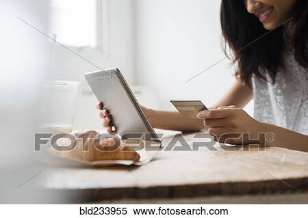 Mixed Race woman online shopping with credit card View Large Photo Image Stock Photography - Mixed Race woman online shopping with credit card. Fotosearch