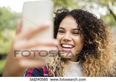Mixed Race woman posing for cell phone selfie View Large Photo Image Stock Photography - Mixed Race woman posing for cell phone selfie. Fotosearch