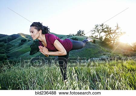 Mixed Race woman practicing yoga on hill View Large Photo Image Stock Photo - Mixed Race woman practicing yoga on hill. Fotosearch