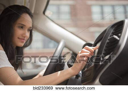 Mixed Race woman pressing touch screen in car View Large Photo Image Stock Photo - Mixed Race woman pressing touch screen in car. Fotosearch
