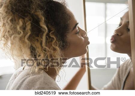 Mixed Race woman puckering lips in mirror View Large Photo Image Stock Photo - Mixed Race woman puckering lips in mirror. Fotosearch