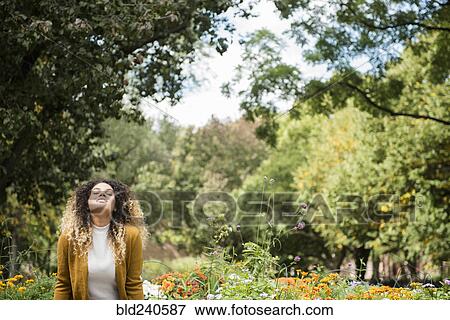 Stock Photo - Mixed Race woman relaxing in park. Fotosearch