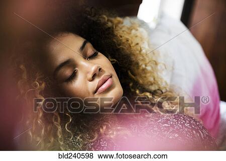 Mixed Race woman relaxing on bed View Large Photo Image Stock Photo - Mixed Race woman relaxing on bed. Fotosearch