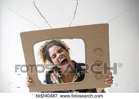 Mixed Race woman screaming in cardboard television View Large Photo Image Stock Photo - Mixed Race woman screaming in cardboard television. Fotosearch