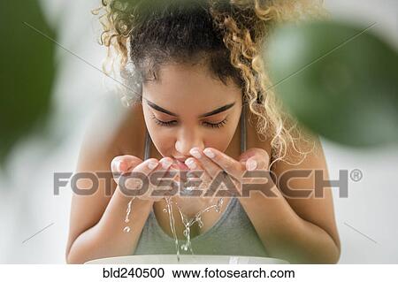 Mixed Race woman splashing water on face View Large Photo Image Stock Image - Mixed Race woman splashing water on face. Fotosearch