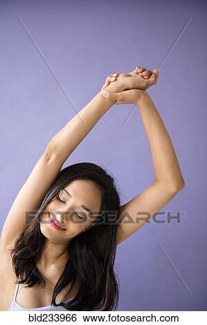 Mixed Race woman stretching arms View Large Photo Image Stock Photograph - Mixed Race woman stretching arms. Fotosearch