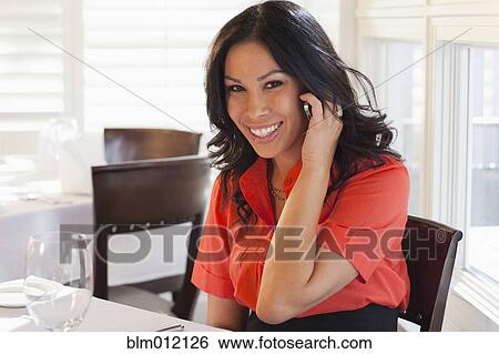 Stock Photograph - Mixed race woman talking on cell phone. Fotosearch