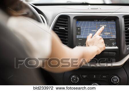 Mixed Race woman using touch screen navigation map in car View Large Photo Image Stock Image - Mixed Race woman using touch screen navigation map in car. Fotosearch