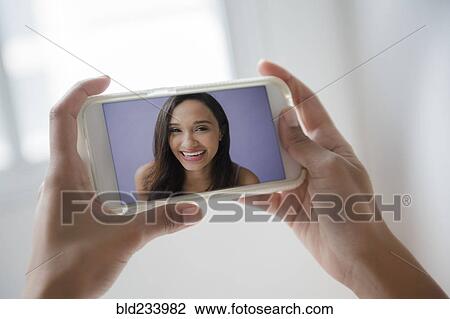 Mixed Race woman video chatting on cell phone View Large Photo Image Stock Image - Mixed Race woman video chatting on cell phone. Fotosearch