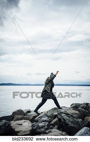 Mixed Race woman walking on rocks near ocean View Large Photo Image Stock Image - Mixed Race woman walking on rocks near ocean. Fotosearch