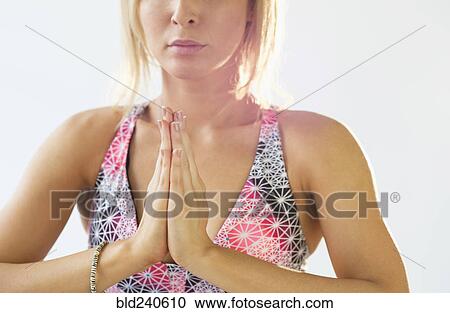 Stock Image - Mixed Race woman with hands clasped in yoga pose. Fotosearch