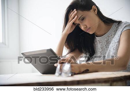 Mixed Race woman with headache using digital tablet View Large Photo Image Stock Photograph - Mixed Race woman with headache using digital tablet. Fotosearch