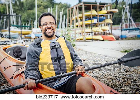 Mixed Rave man sitting in kayak holding paddle View Large Photo Image Stock Photo - Mixed Rave man sitting in kayak holding paddle. Fotosearch