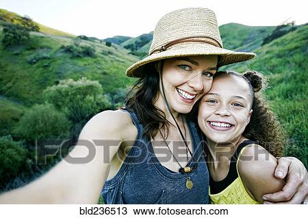 Stock Image - Mother and daughter posing for selfie. Fotosearch