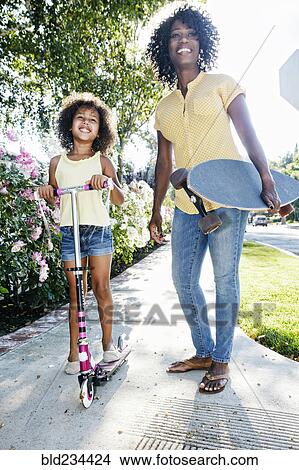 Picture - Mother and daughter posing on sidewalk. Fotosearch