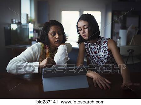 Mother and daughter using digital tablet View Large Photo Image Stock Image - Mother and daughter using digital tablet. Fotosearch
