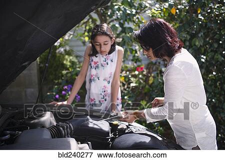 Mother teaching daughter about car engine View Large Photo Image Stock Photo - Mother teaching daughter about car engine. Fotosearch
