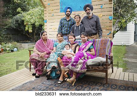 Stock Image - Multi-generation family posing on patio bench. Fotosearch