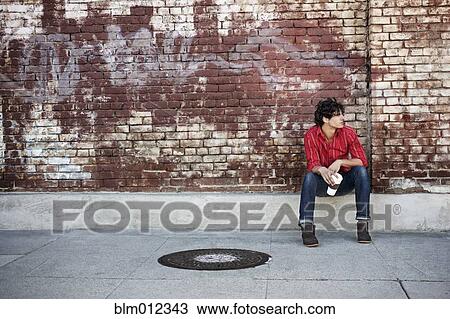 Stock Image - Native American man drinking coffee in urban area. Fotosearch