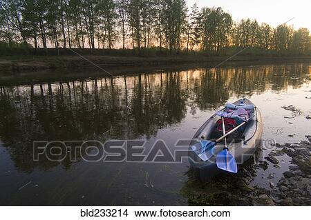 Picture - Oars on empty inflatable raft on river. Fotosearch