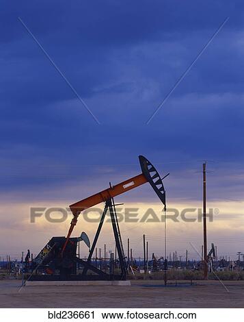 Oil rig drilling at sunset View Large Photo Image Stock Image - Oil rig drilling at sunset. Fotosearch