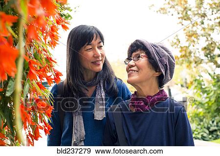 Stock Photo - Older Japanese mother and daughter near autumn leaves. Fotosearch