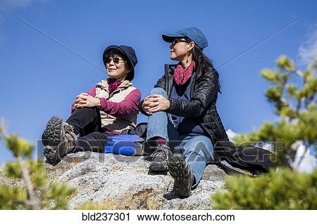 Older Japanese mother and daughter sitting on rock View Large Photo Image Stock Image - Older Japanese mother and daughter sitting on rock. Fotosearch