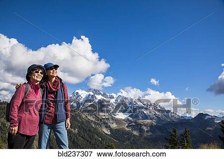 Stock Photo - Older Japanese mother and daughter standing near mountain. Fotosearch