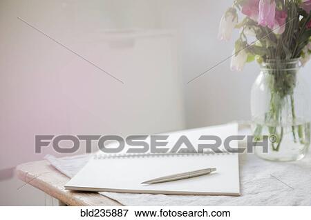 Pen on open blank notebook near flowers View Large Photo Image Stock Photo - Pen on open blank notebook near flowers. Fotosearch